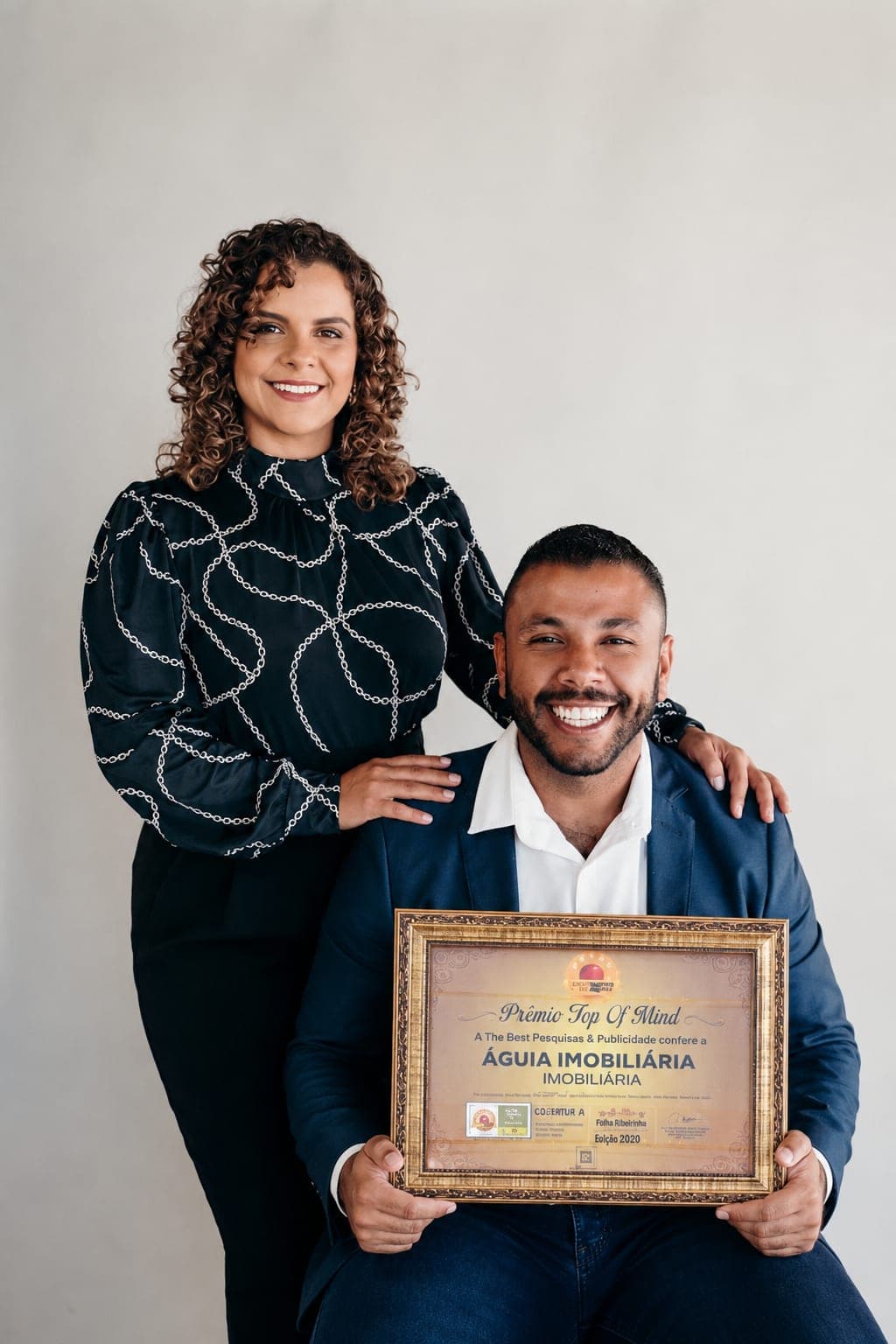 Patrícia Valadares e Matheus Ferreira segurando o prêmio Top of Mind 2020